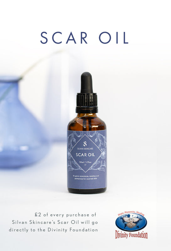 Silvan Skincare Scar Oil in an amber glass dropper bottle with a lavender label, set against a white background with a blurred blue beaker. Text at the top reads 'SCAR OIL' and a donation message at the bottom directs purchase proceeds to the Divinity Foundation.