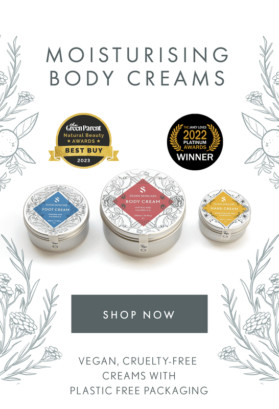 Three Silvan Skincare moisturizing body cream tins with decorative labels on a white background with floral elements.